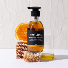 Load image into Gallery viewer, Bottle of Fur Love shampoo with an orange, honeycomb, and glass on a light background