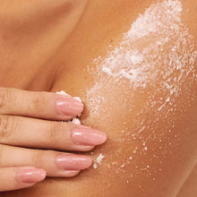Load image into Gallery viewer, Close-up of a person's arm and hand with white sugar body scrub from LALICIOUS being rubbed onto the skin.